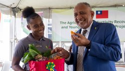 Prime Minister Godwin Friday, right, and a participant in the Agricultural Productivity Recovery and Young Farmers Training Project at the launch in Orange Hill on Tuesday, May 19, 2026.