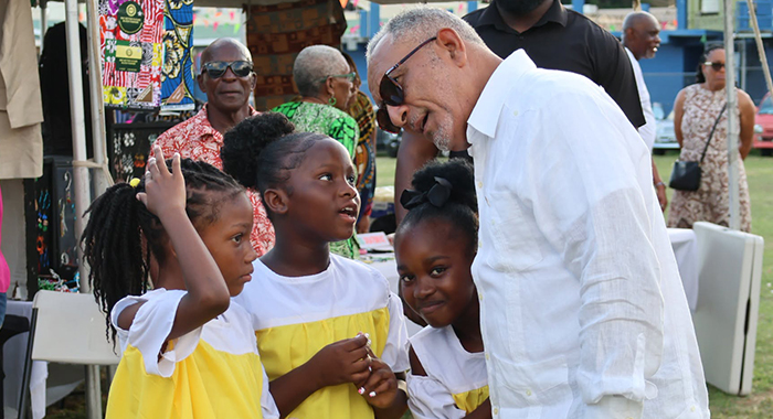 Prime Minister Godwin Friday interacts with children at the Emancipation Day event at Independence Park in Kingstown on Saturday, Aug. 1, 2026. 
