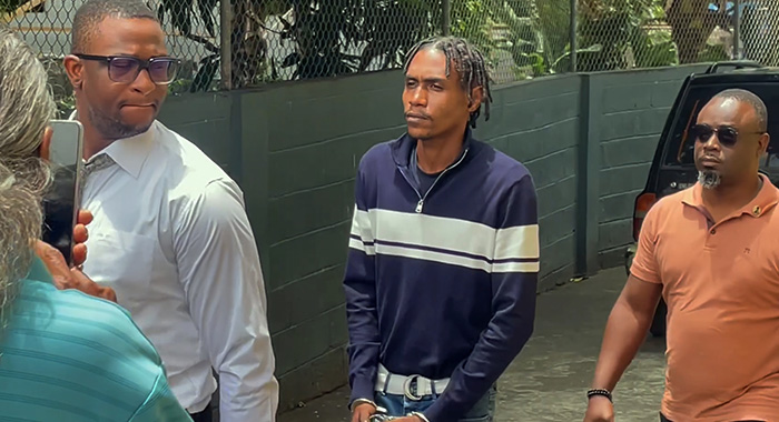 Murder accused Rhyse Henry in police custody outside the Serious Offences Court in Kingstown on Thursday, Aug. 6, 2026. 