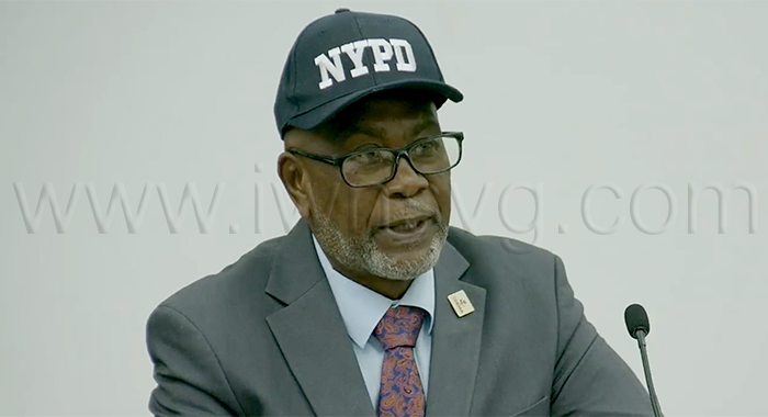 Deputy Prime Minister and National Security Minister St. Clair Leacock wears an "NYPD" cap as he speaks in Parliament on Aug. 27, 2026.