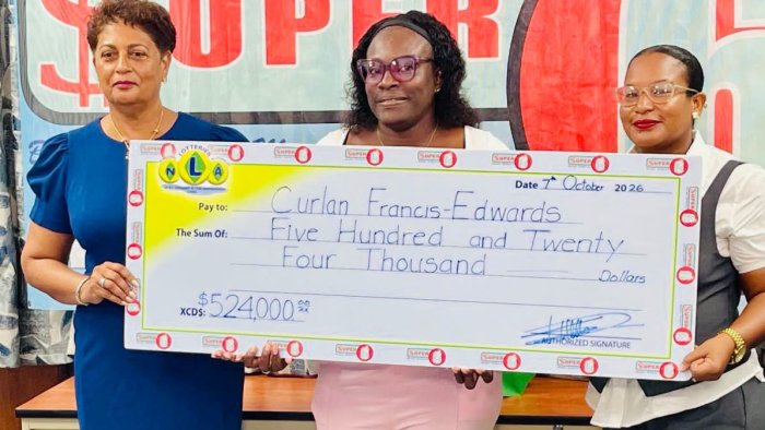 Jackpot Winner Presented: National Lotteries Authority (NLA) Chairperson Luann Hadaway (left) and an NLA official (right) present Curlan Francis Edwards (center) with her promotional cheque for EC$524,000 at the NLA headquarters in Kingstown on Wednesday, October 7, 2026.