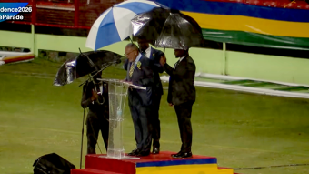 Bodyguards use umbrellas to protect Prime Minister Godwin Friday from heavy rains as he delivers his independence address in Arnos Vale on Tuesday, Oct. 27, 2026. 