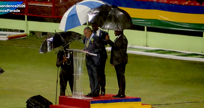 Bodyguards use umbrellas to protect Prime Minister Godwin Friday from heavy rains as he delivers his independence address in Arnos Vale on Tuesday, Oct. 27, 2026. 